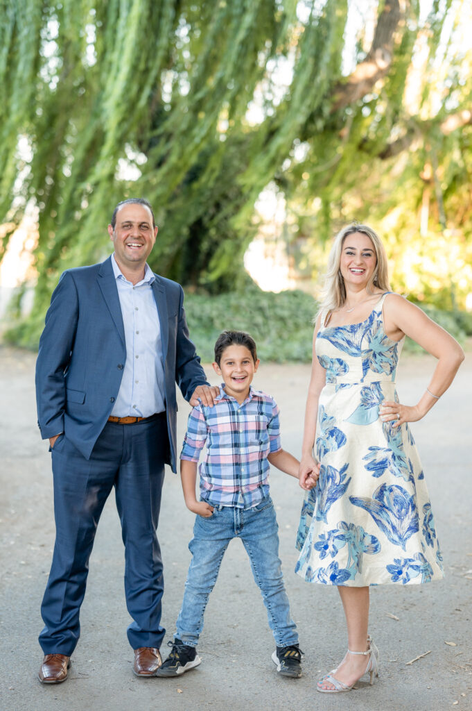 Family of three posing and smiling at family photo session at West 12 Ranch with Gia Chong Photography, Lodi CA photographer