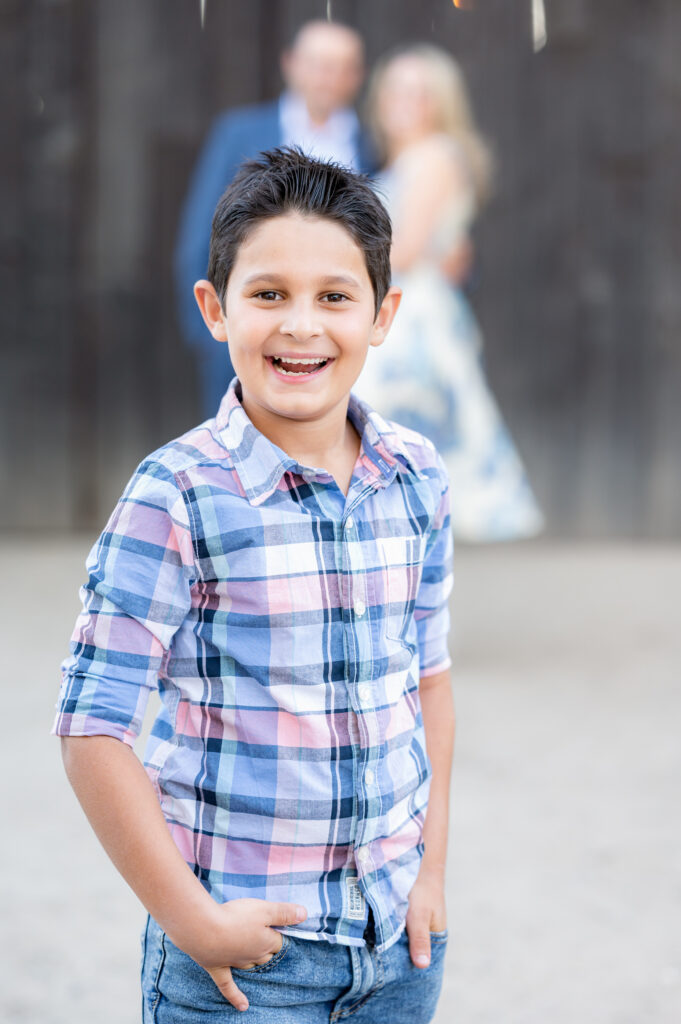 Son posing by himself and his parents behind him at family photo shoot at West 12 Ranch with Gia Chong Photography, Lodi CA photographer