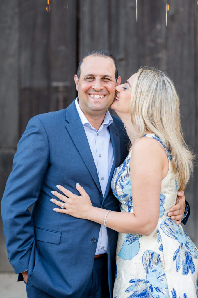 Mom and dad in front of barn doors at family shoot at West 12 Ranch with Gia Chong Photography, Lodi CA photographer