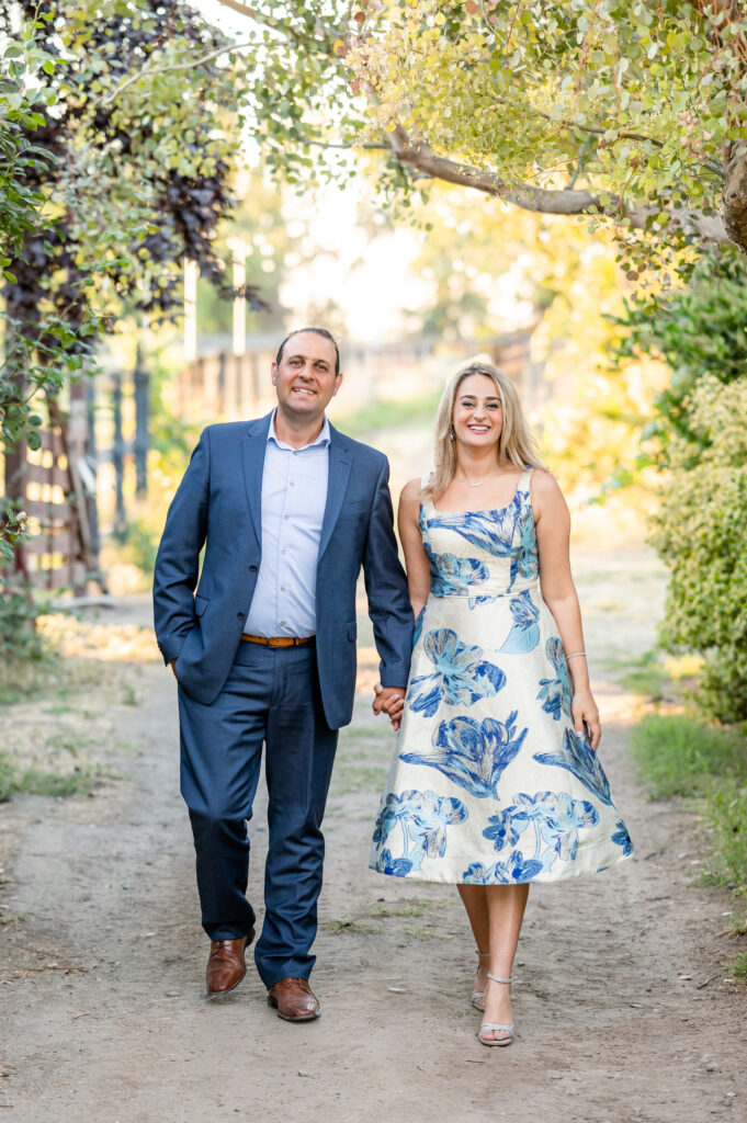 Mom and dad walking together at a dirt road at portrait session at West 12 Ranch with Gia Chong Photography, Lodi CA photographer