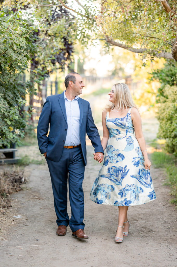 Mom and dad walking together at a dirt road at portrait session at West 12 Ranch with Gia Chong Photography, Lodi CA photographer