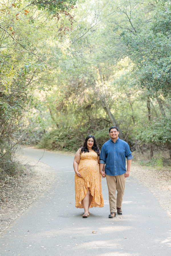 Dad and pregnant mom walking on a nature trail during a maternity session at Lodi Lake Park, Lodi CA with Gia Chong Photography, Lodi Photographer