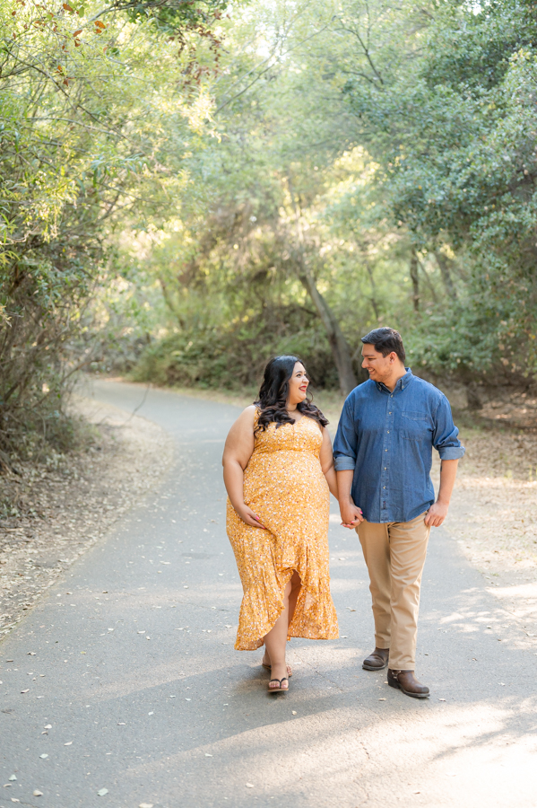Dad and pregnant mom walking on a nature trail during a maternity session at Lodi Lake Park, Lodi CA with Gia Chong Photography, Lodi Photographer