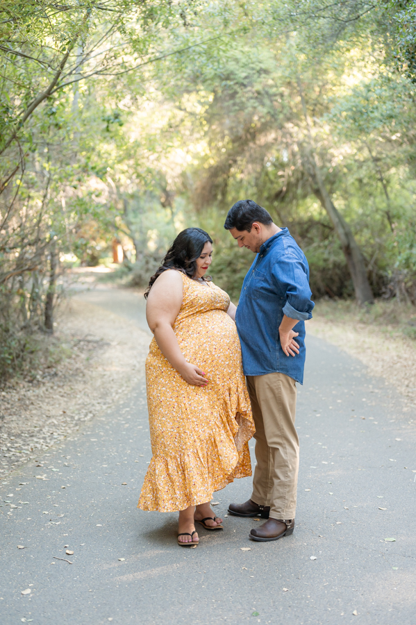 Dad and pregnant mom posing on a nature trail during a maternity session at Lodi Lake Park, Lodi CA with Gia Chong Photography, Lodi Photographer