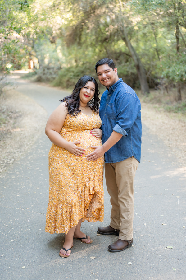 Dad and pregnant mom posing on a nature trail during a maternity session at Lodi Lake Park, Lodi CA with Gia Chong Photography, Lodi Photographer
