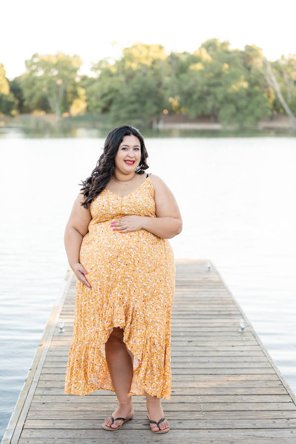 Pregnant mom posing n a dock near the water during a maternity session at Lodi Lake Park, Lodi CA with Gia Chong Photography, Lodi Photographer