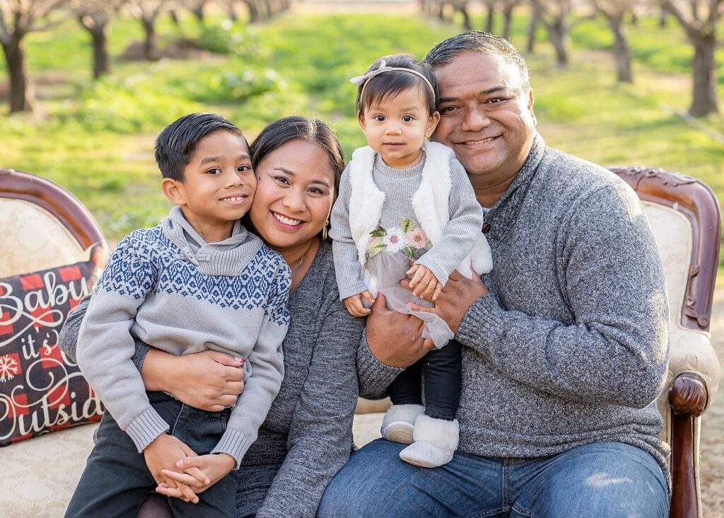 family seated on a couch pose idea