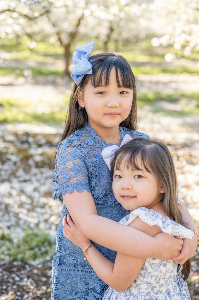 Sisters hugging pose idea almond blossoms photo session