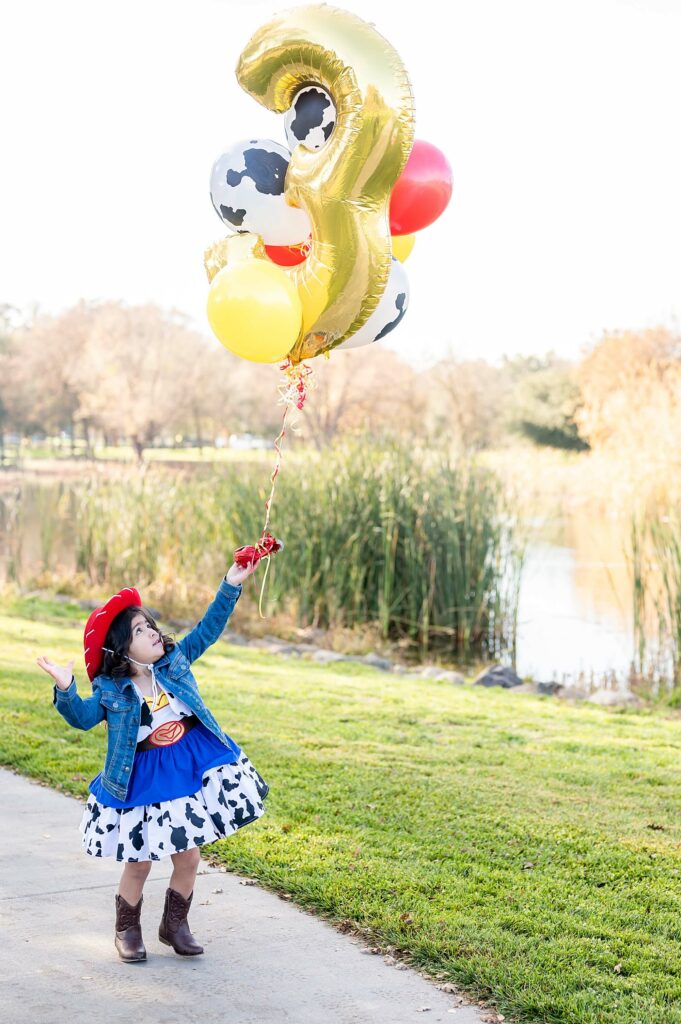 Little girl holding balloons pose
