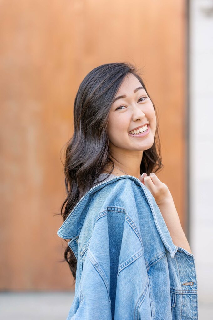 Senior girl standing with jacketpose idea