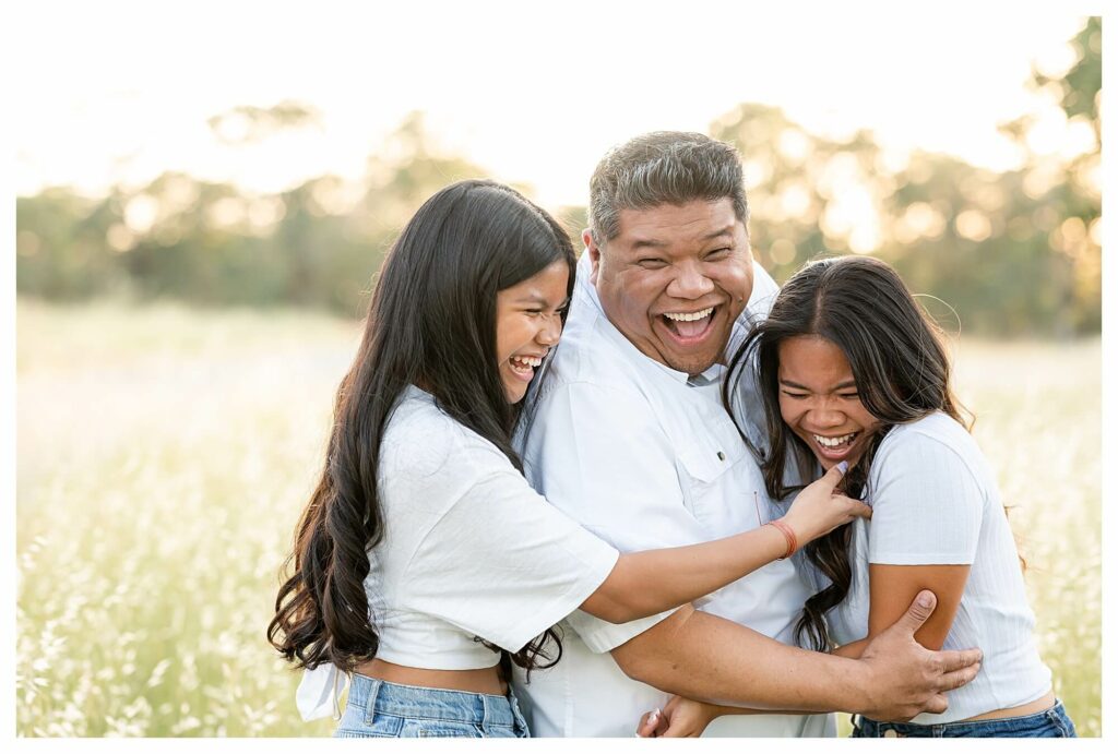 dad tickling teenage daughters during outdoor family photo session Roseville CA