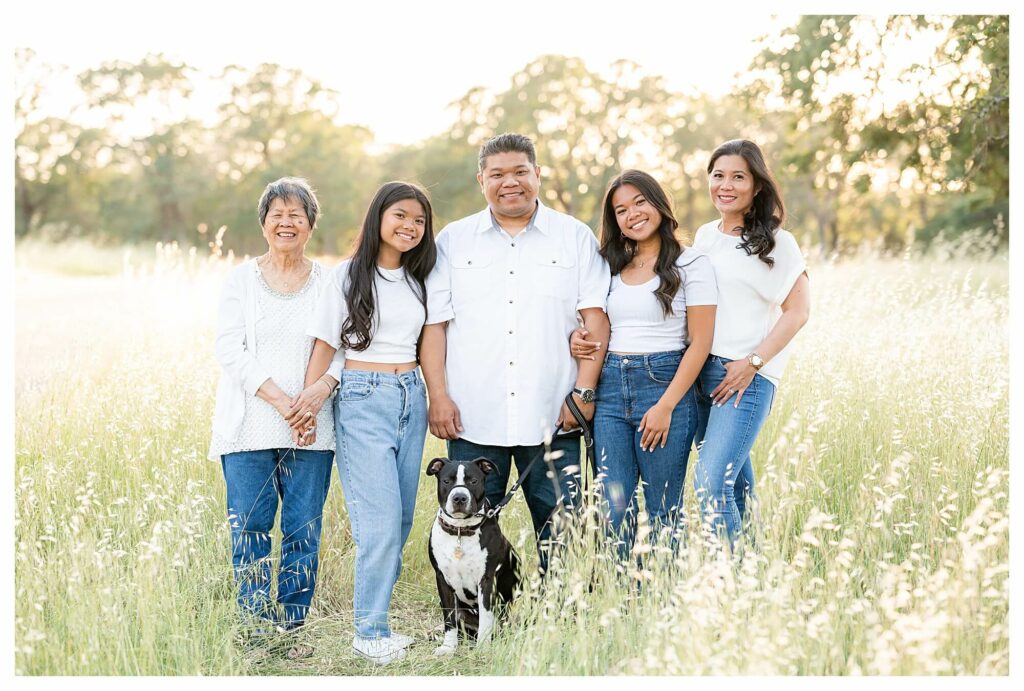 family with their dog smiling at the camera