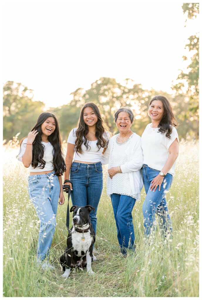 grandmother, mother and daughters posing with the family dog