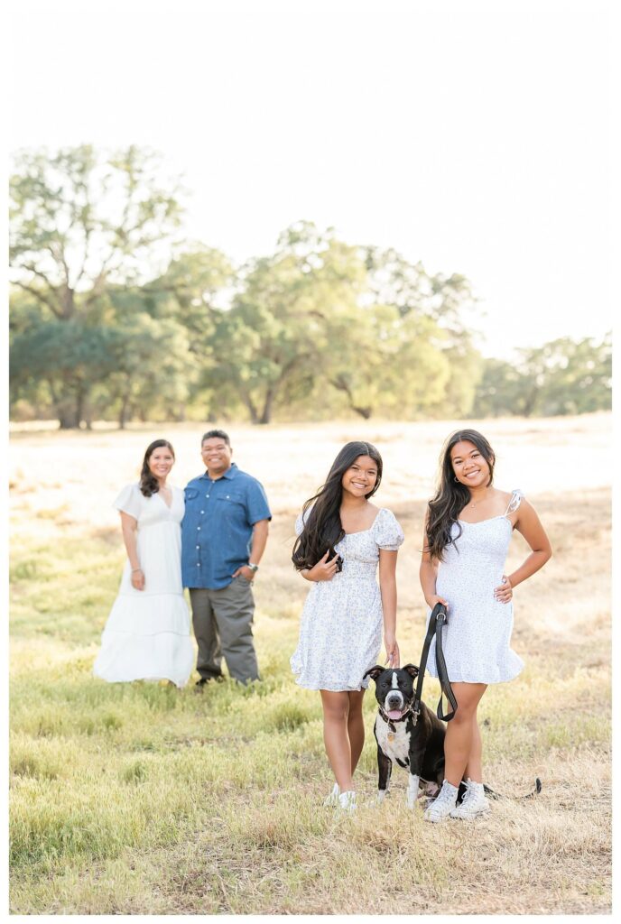 daughters and dog posing in front of parents