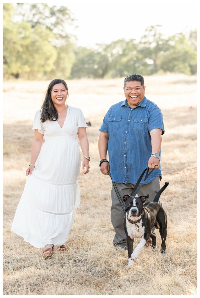 mom and dad walking with family dog during outdoor family photo session Roseville CA