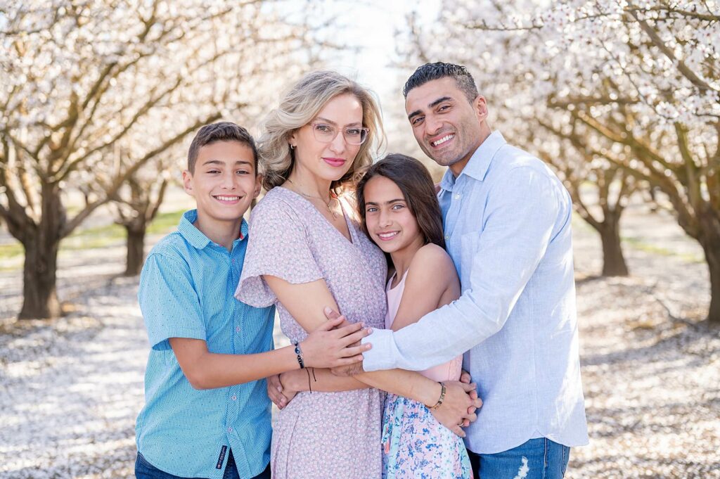 family hugging during almond blossom photo shoot