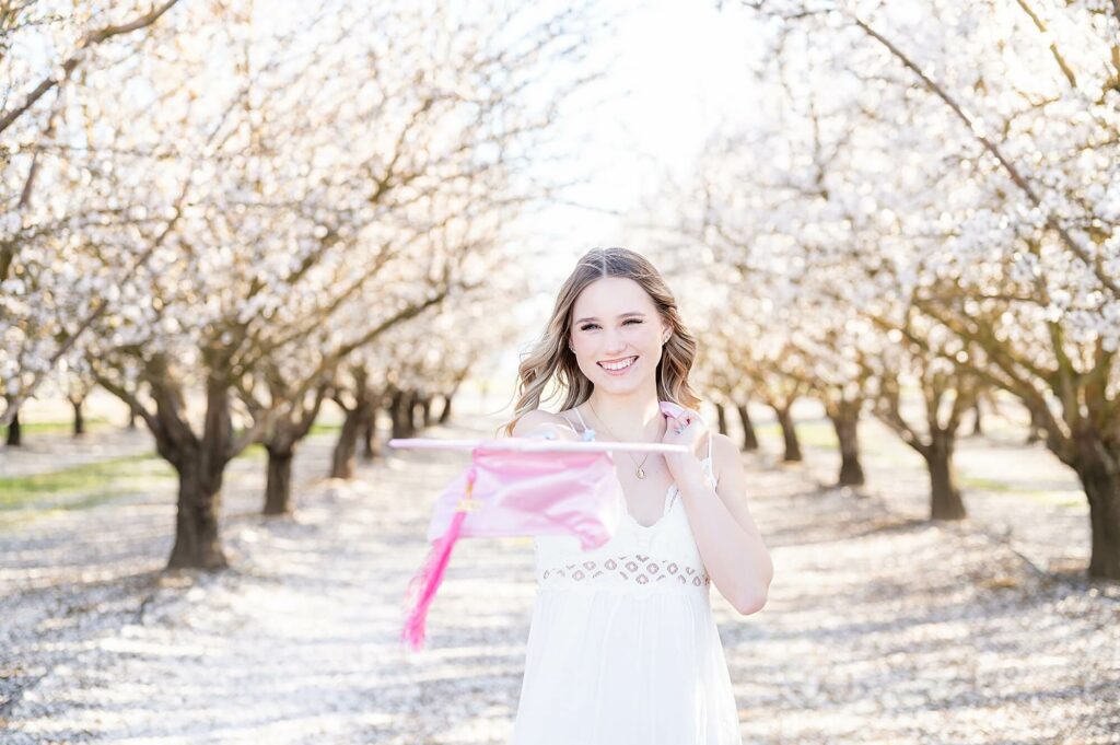 senior holding a pink graduation cap