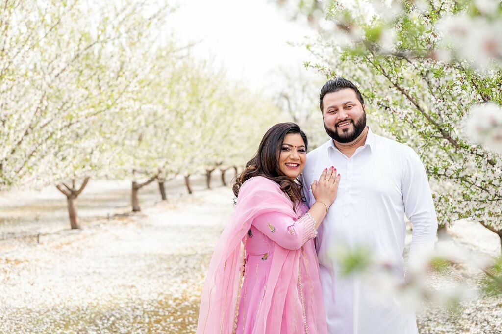 couple standing and smiling at the camera posing idea