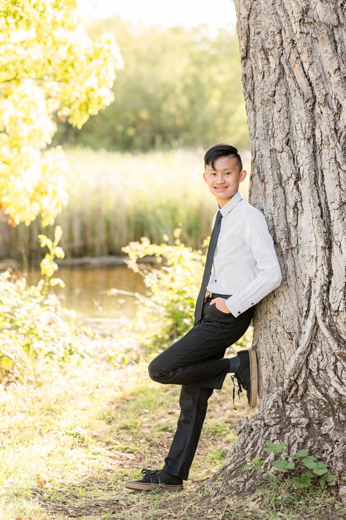 young man leaning against a tree posing idea