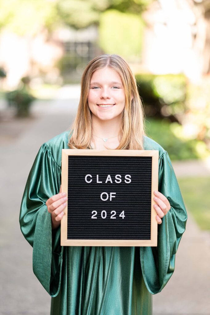 Grad girl posing with graduating class sign