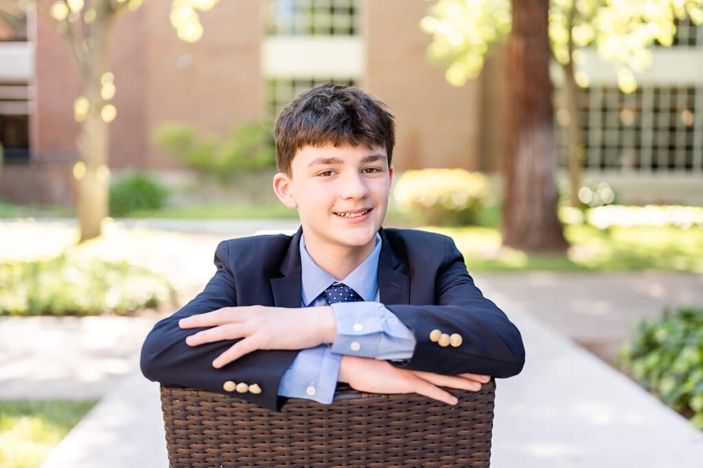 sitting pose for graduating boy