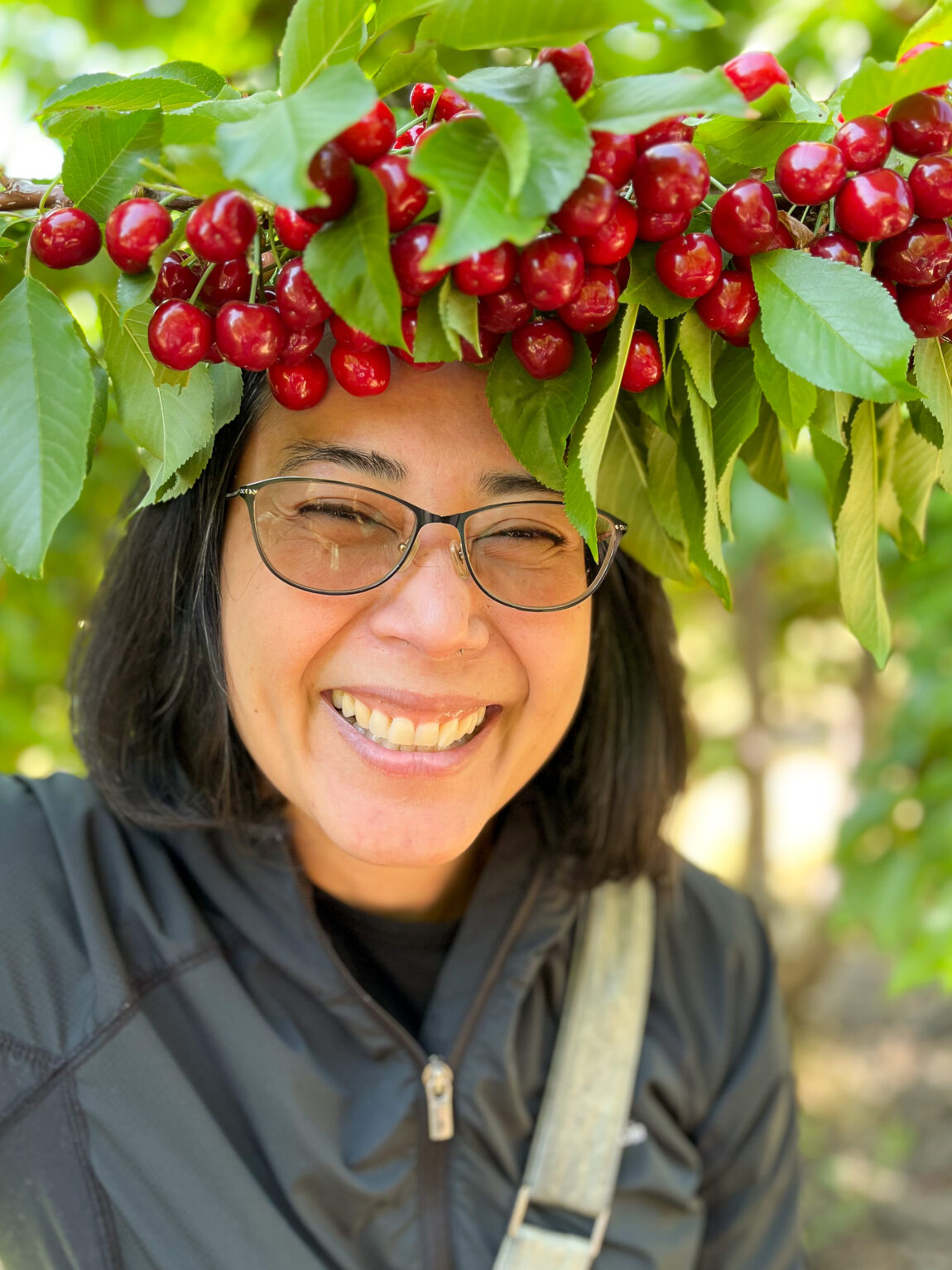Woman smiling with a crown of cherries in a cherry farm