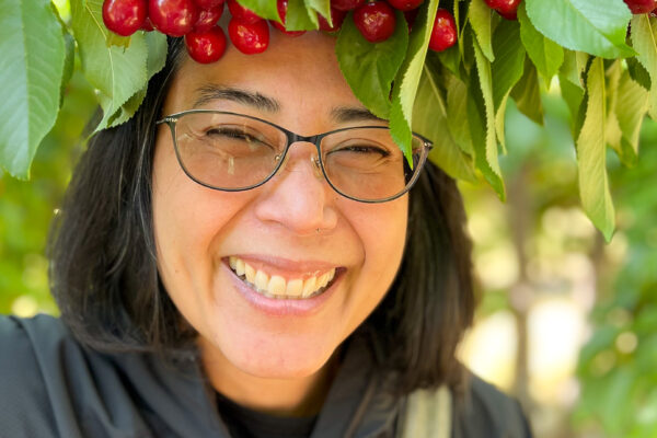 Woman smiling with a crown of cherries in a cherry farm
