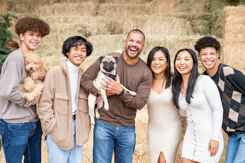Family smiling at the camera and holding their dogs