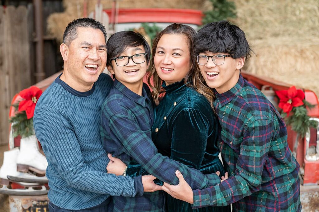 Family hugging and laughing at the camera