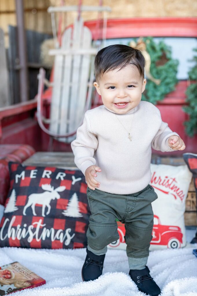 baby boy posing idea during red truck christmas mini session