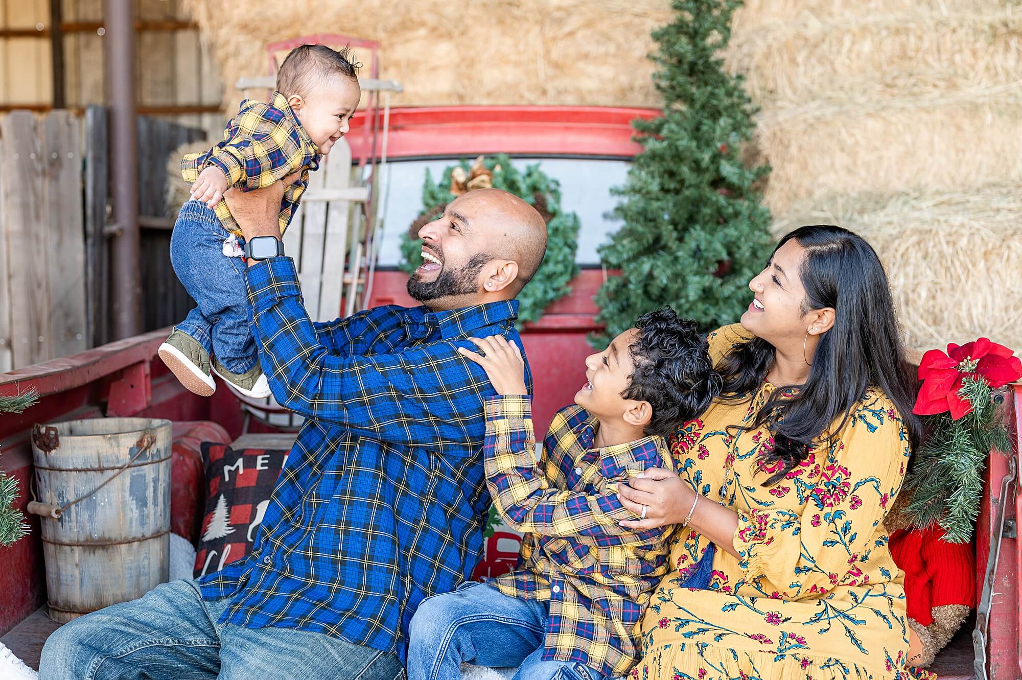 family playing baby during a red truck christmas mini session