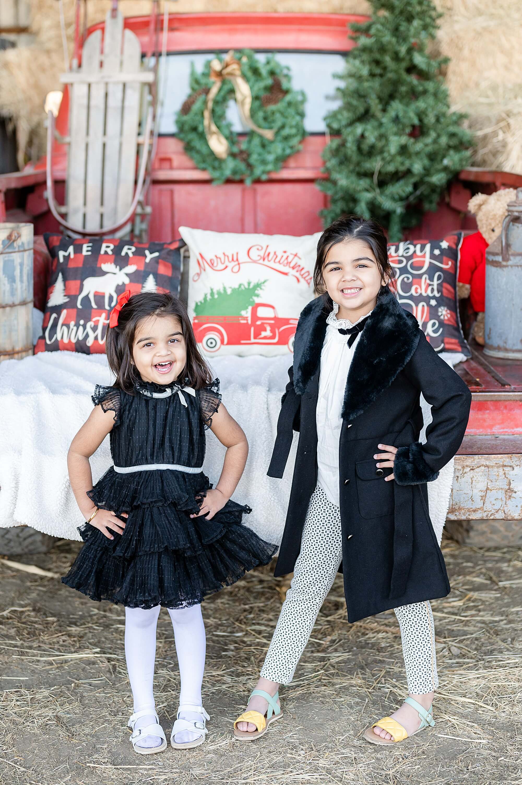 sisters posing in front of a red truck