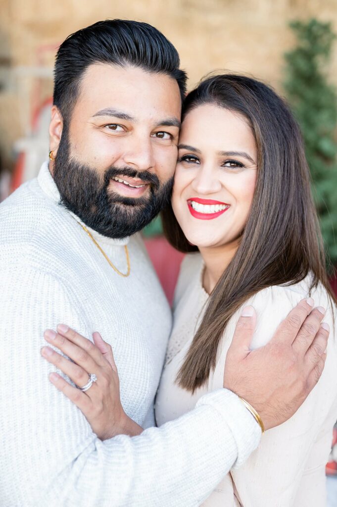 parents smiling and hugging during a red truck mini session