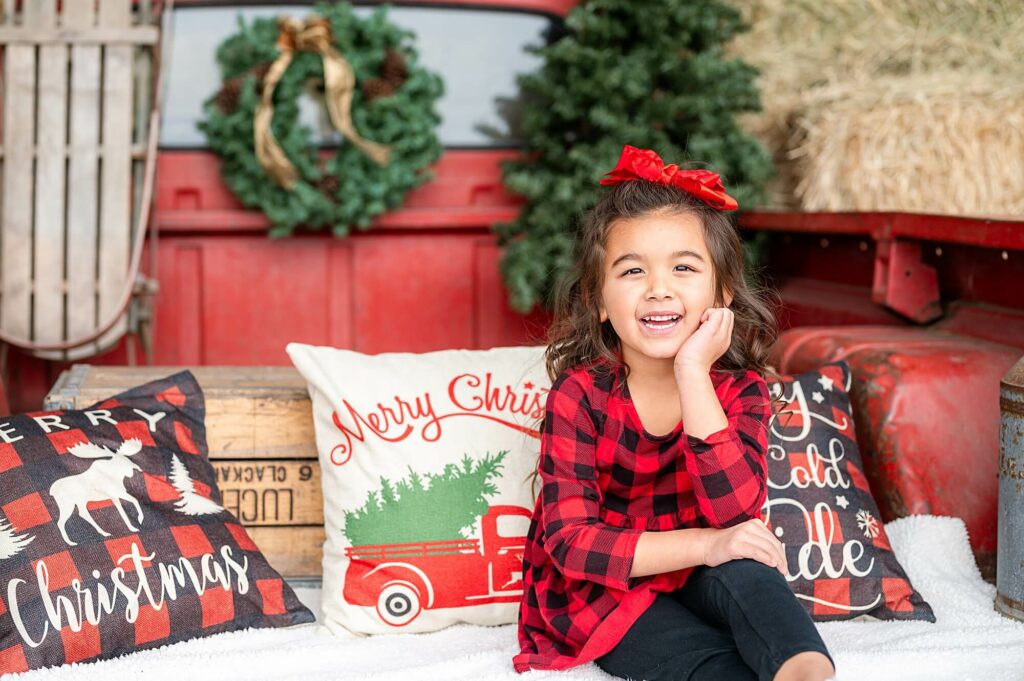 posing idea for little girls during red truck christmas mini sessions