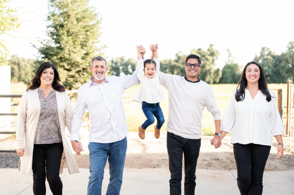 Family walking and laughing during a family photo session at Champaign Ranch in Herald CA