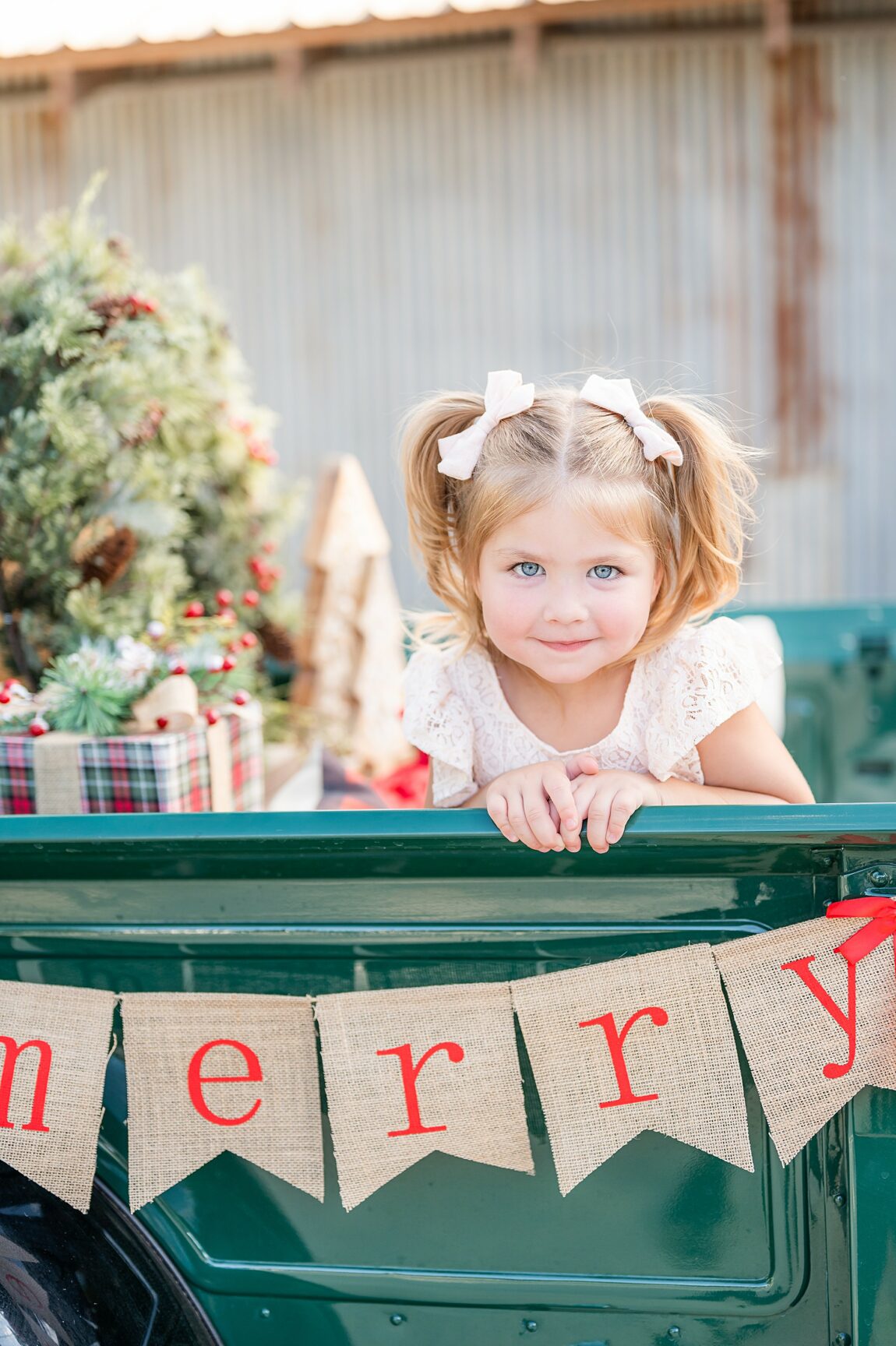 Little girl smiling at the camera in a truck bed during a Vintage Truck Christmas Mini Session in Champaign Ranch