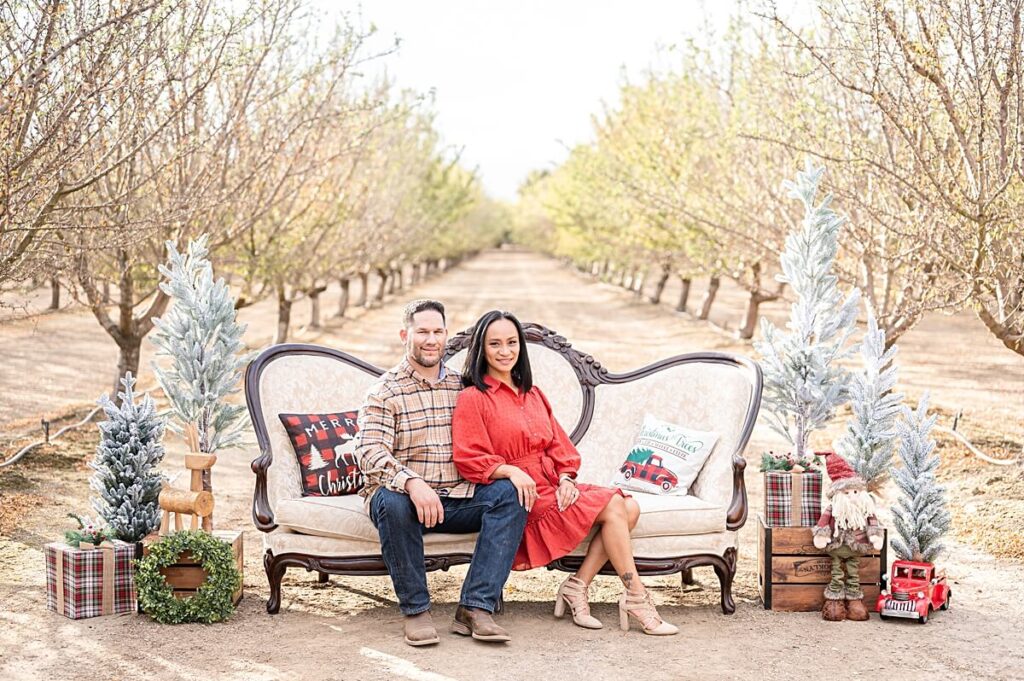 parents smiling at the camera on a Christmas Couch at Golden R Ranch Stockton CA