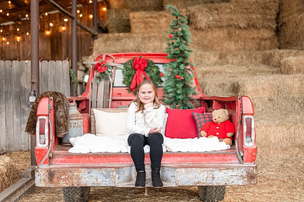 Young girl seated on Christmas Red Truck at West 12 Ranch