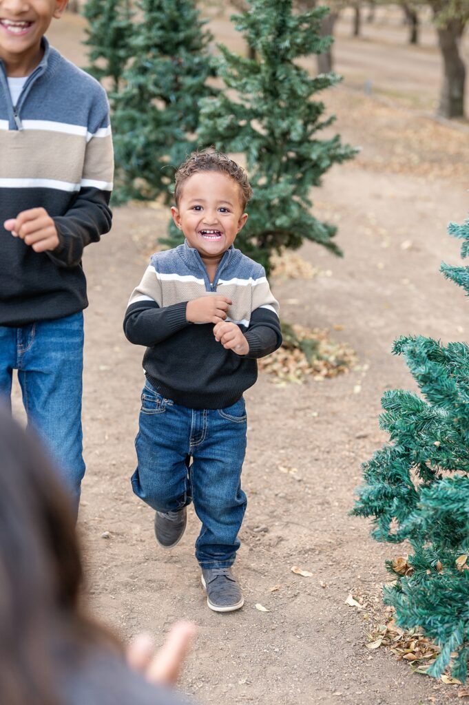Little boy walking and laughing during their family holiday session in Stockton CA