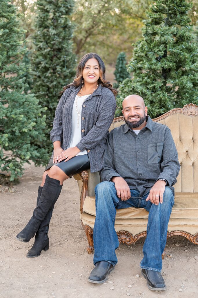Parents seated and smiling at the camera during their Holiday family photo shoot