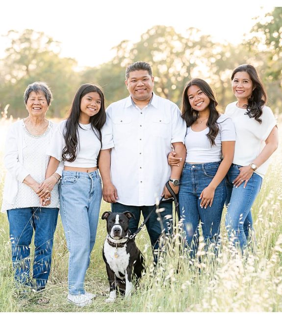 family with their dog smiling at the camera